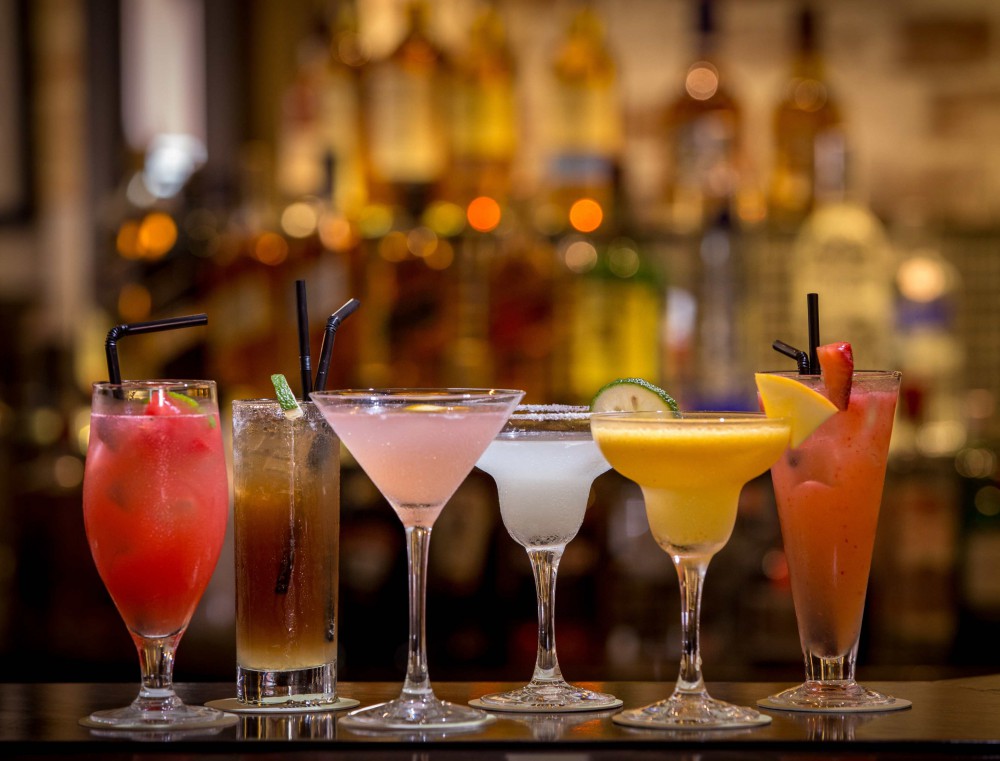 6 bicchieri con cocktail colorati in rosso arancione e giallo pronti per essere bevuti, Studio Aschei corsi per diventare barman.